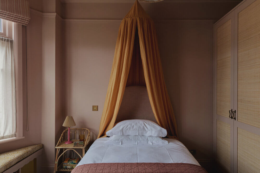 Warm Colors and Texture In A North London Family Home 14 pink-bedroom-yellow-canopy-cane-wardrobe-studio-duggan