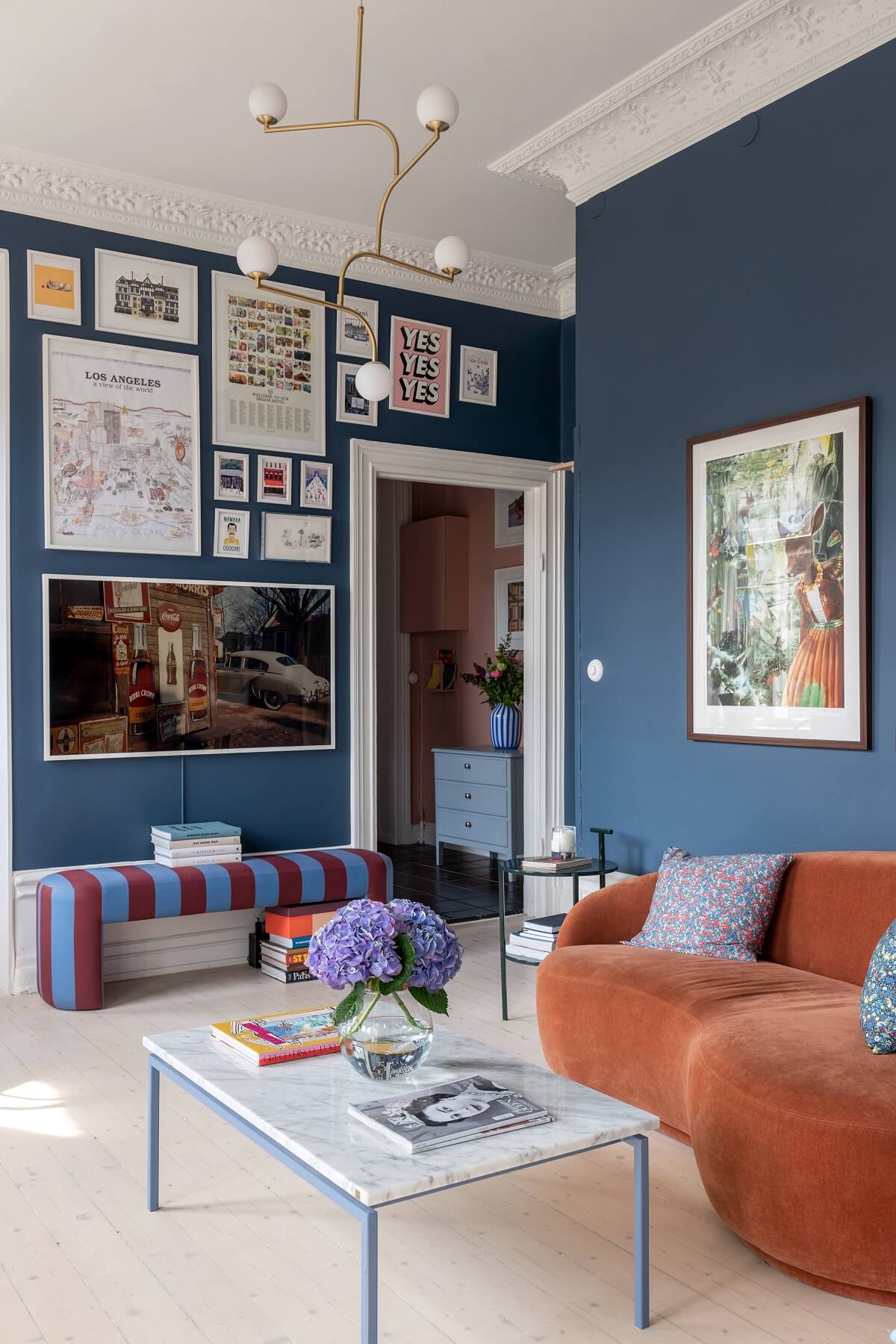 blue-sitting-room-gallery-wall-curved-orange-sofa-nordroom