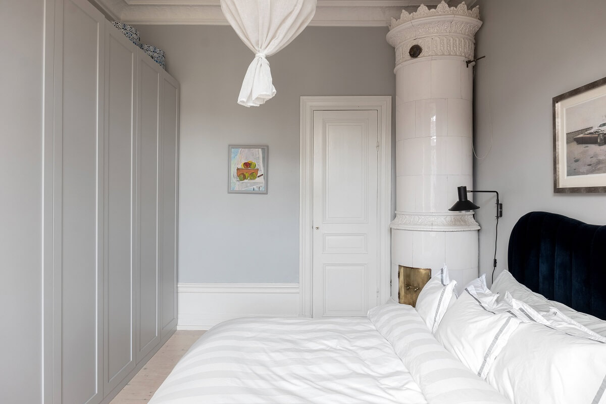 A Nordic Home with Blue Sitting Room and Kitchen 20 light-gray-bedroom-green-velvet-headboard-fireplace-built-in-wardrobes-nordroom