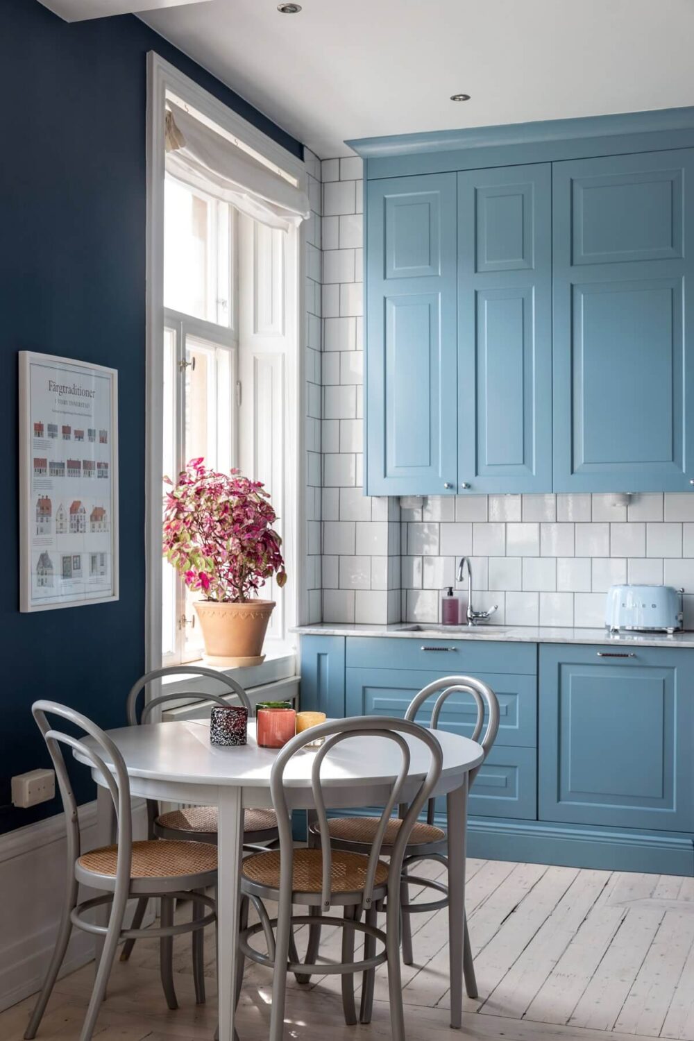 A Nordic Home with Blue Sitting Room and Kitchen 8 small-round-dining-table-bistro-chairs-blue-kitchen-cabinets-nordroom