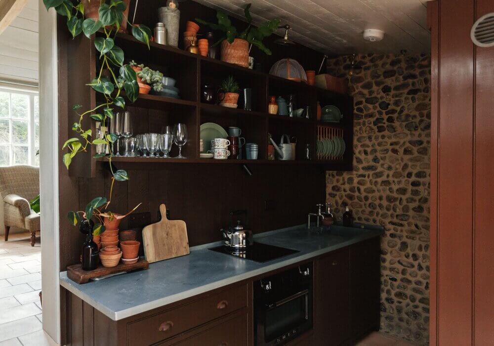 The Color Trends for 2025: Warm, Natural Shades and a Cheerful Accent 90 brown-kitchen-cabinets-stone-wall-open-cabinets-nordroom