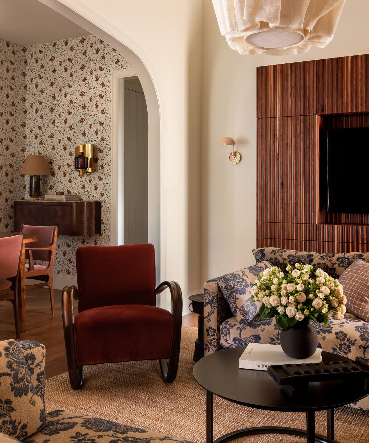 Pink Tones and Black in a Stunning Fox Island Home 10 sitting-room-arched-doorway-red-velvet-armchair-nordroom