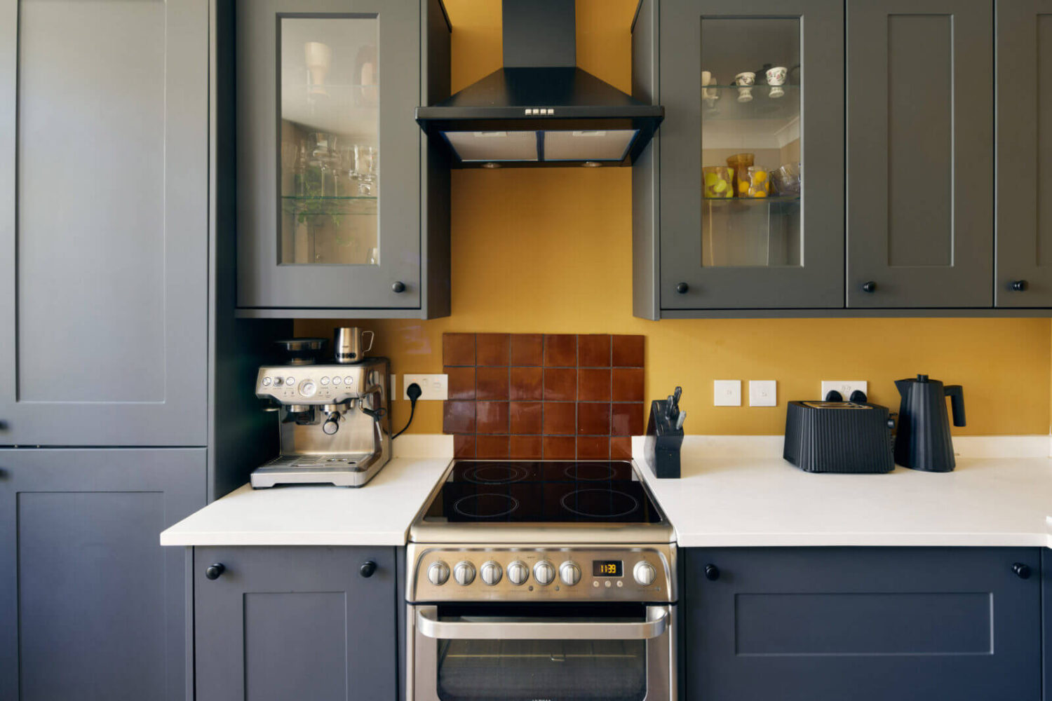 A One-Bedroom Apartment with Colorful Rooms 5 gray-kitchen-cabinets-yellow-walls-nordroom