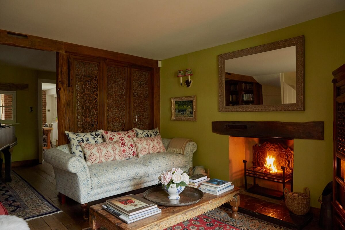 A Charming Arts and Crafts Cottage in the English Countryside 1 cottage-sitting-room-green-walls-fireplace-carved-wooden-wall-nordroom