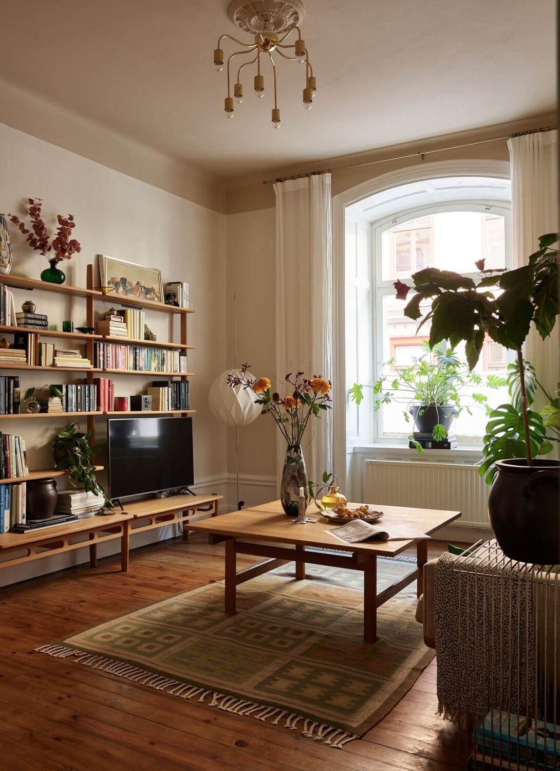 A Charming Vintage Apartment in Stockholm 1 living-room-wooden-floor-painted-ceiling-bookshelves-vintage-style-nordroom