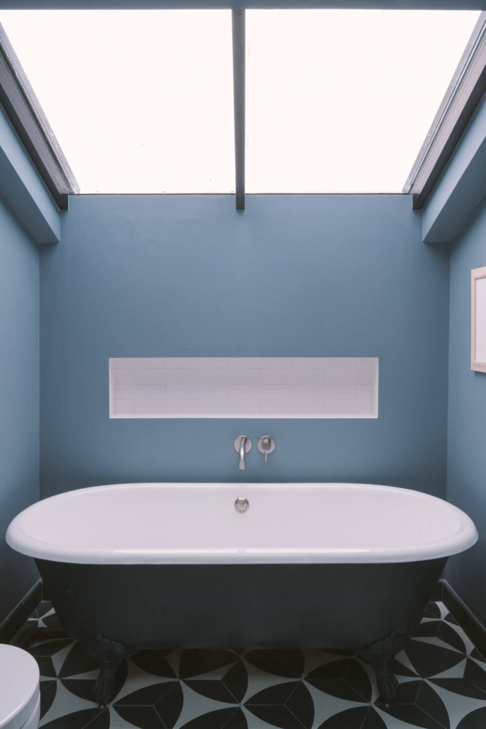 A Modern Split-Level Home with Colorful Rooms 25 freestanding-bath-blue-walls-skylight-nordroom