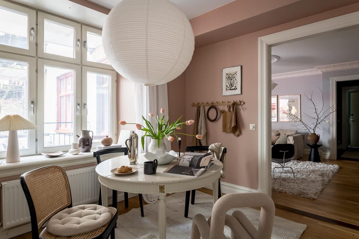 Layered Textiles and Dusty Colors in a Nordic Apartment 12 round-dining-table-mixture-of-chairs-dusty-pink-walls-nordroom