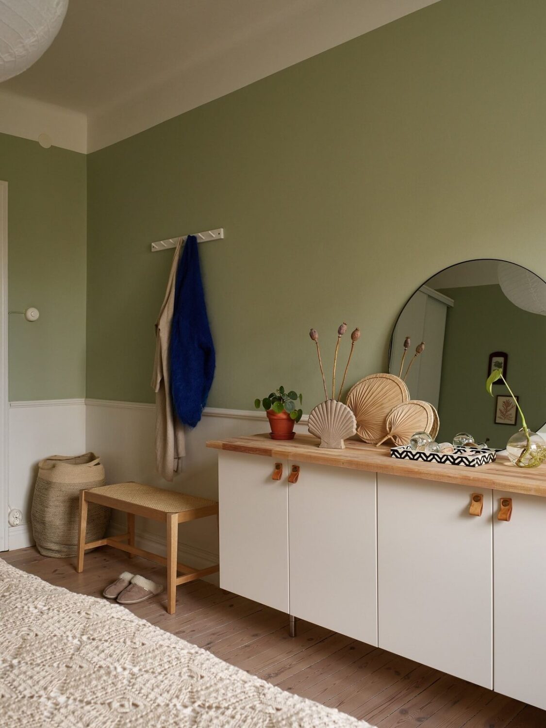 A Scandinavian Apartment with a Light Green Bedroom 17 light-green-walls-white-cabinets-wooden-top-round-mirror-bedroom-nordroom
