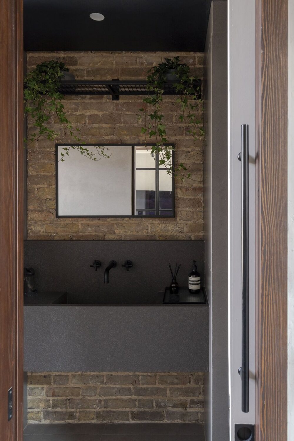 A Victorian House with Stylish Contemporary Interiors 10 powder-room-brick-wall-modern-gray-sink-nordroom