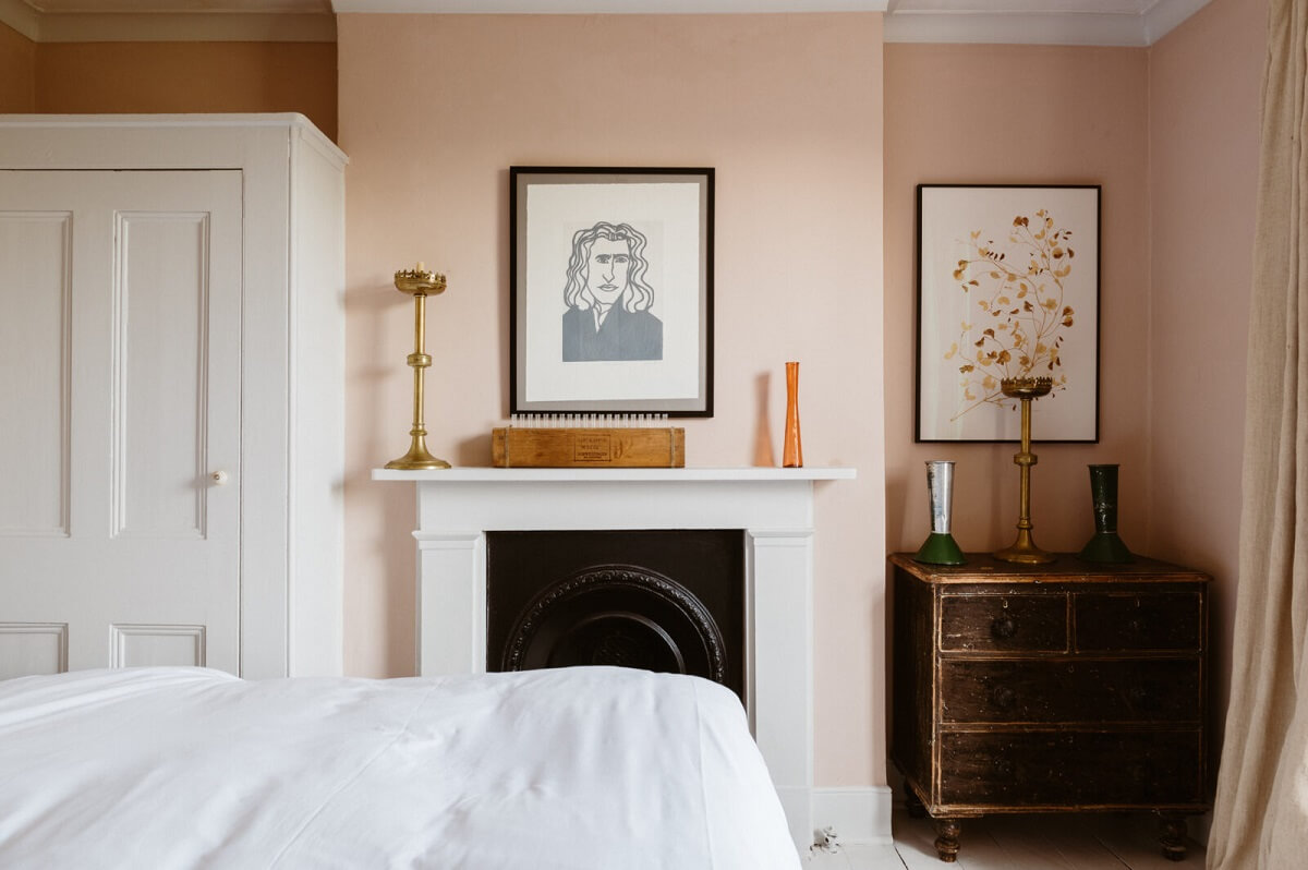 A Cozy Victorian House with Warm Color Accents 13 bedroom-light-pink-walls-fireplace-nordroom