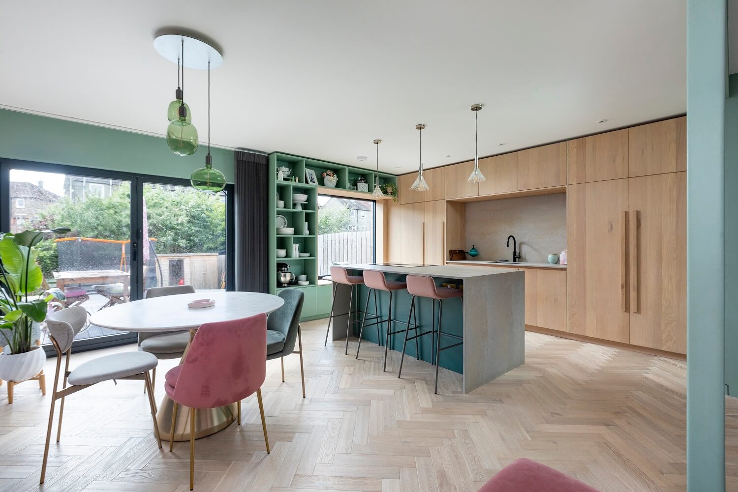 An Open-Plan Living and Kitchen in Green and Pink Tones 1 open-plan-kitchen-dining-green-pink-color-palette-oak-cabinets-nordroom