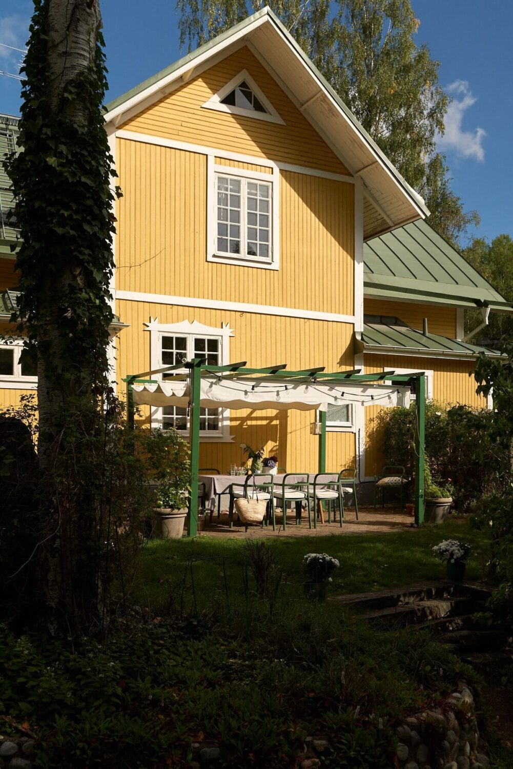 A Beautiful Swedish Country House with a Large Garden 33 yellow-exterior-garden-dining-area-nordroom