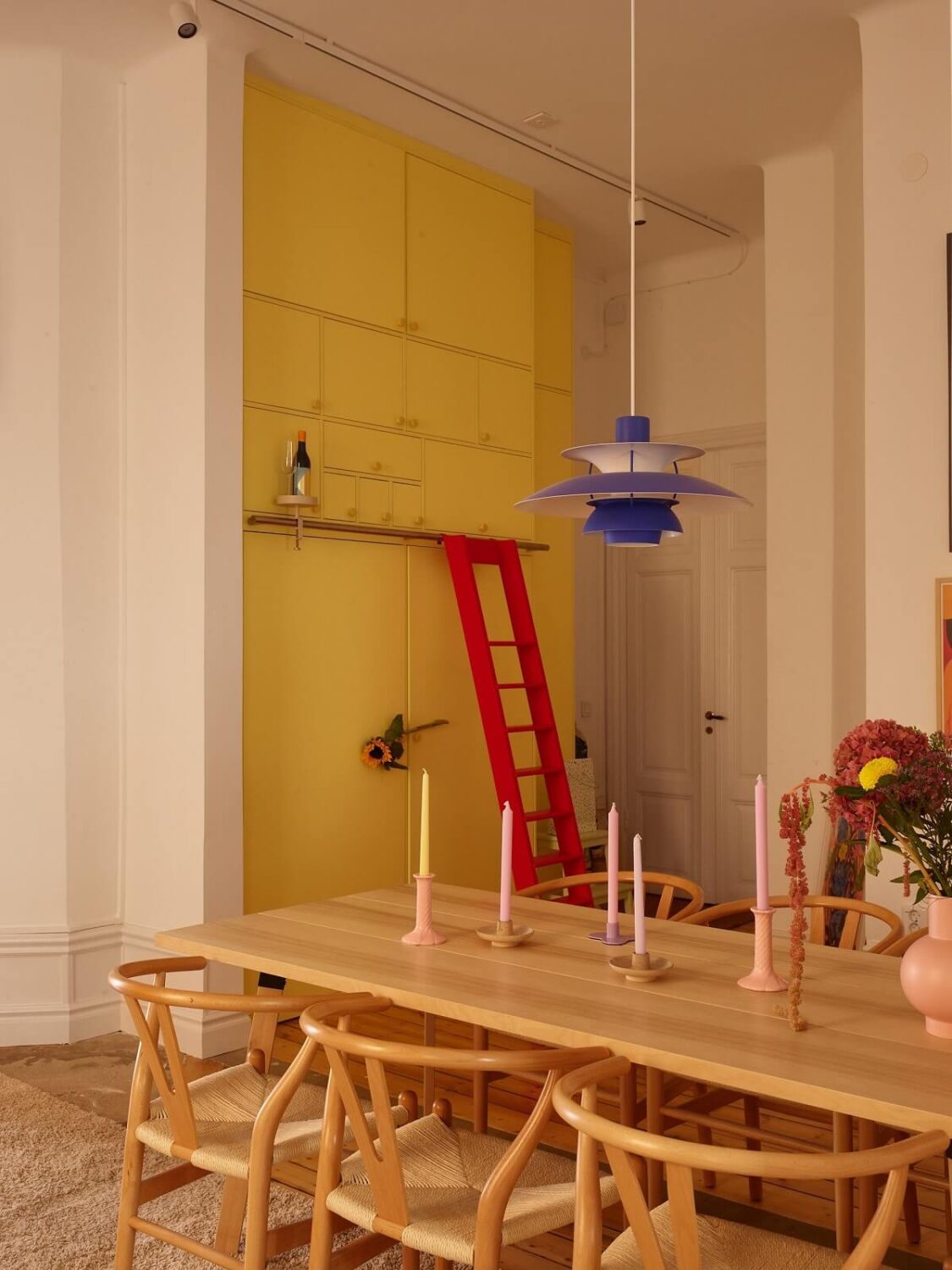 A Small Stockholm Apartment Filled with Color 9 built-in-yellow-cabinets-with-ladder-nordroom