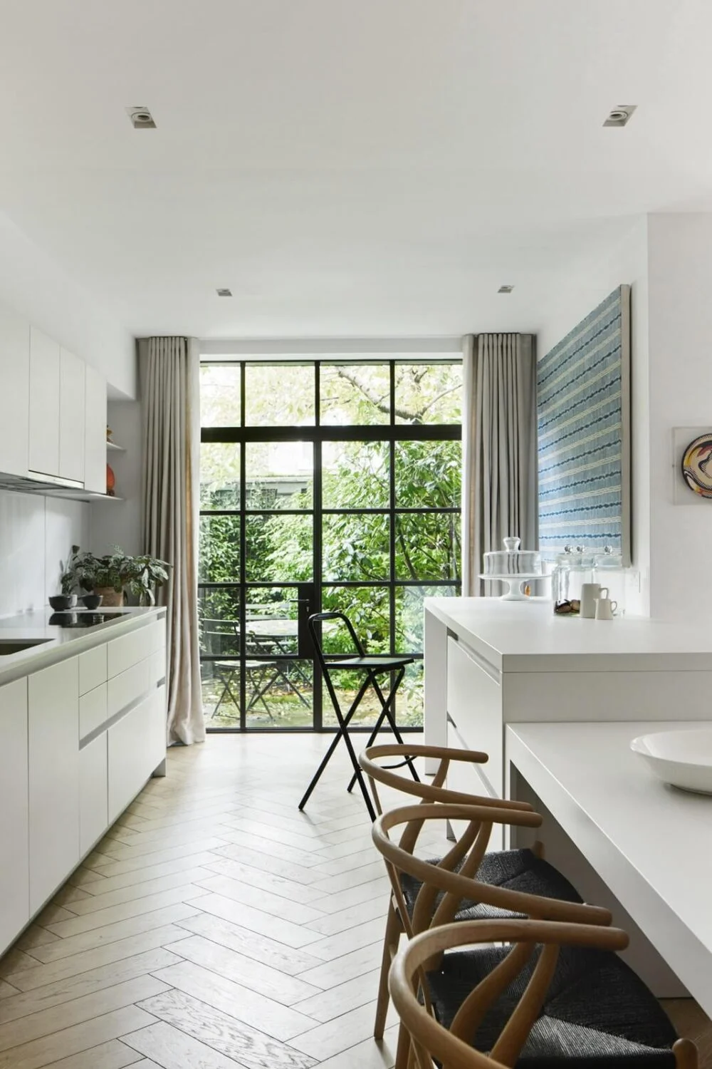 Stylish Monochrome Interiors in an Early 20th Century House 9 kitchen-white-cabinets-bar-seating-crittal-doors-garden