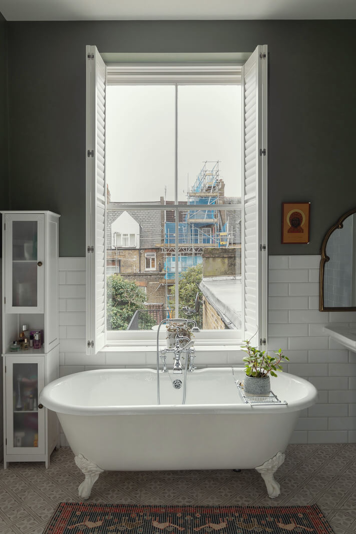 A Victorian House in London with Three Outdoor Spaces 20 bathroom freestanding bath in front of window gray walls nordroom