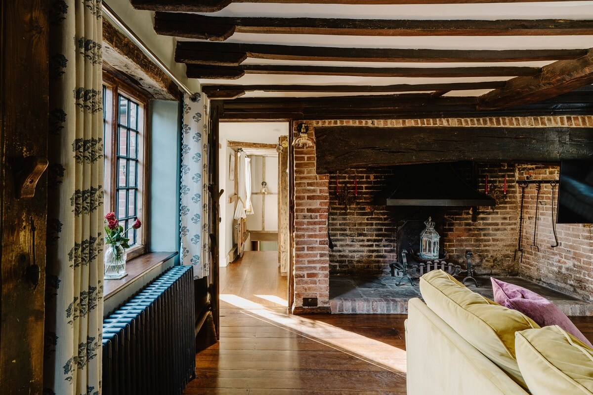 A Cozy Historic English Country House with Exposed Beams 8 brick fireplace living room exposed wooden beams nordroom