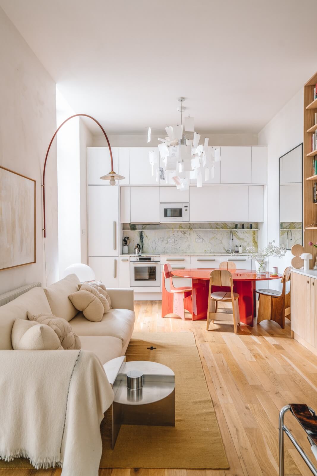light open plan living space with kitchen and red dining table
