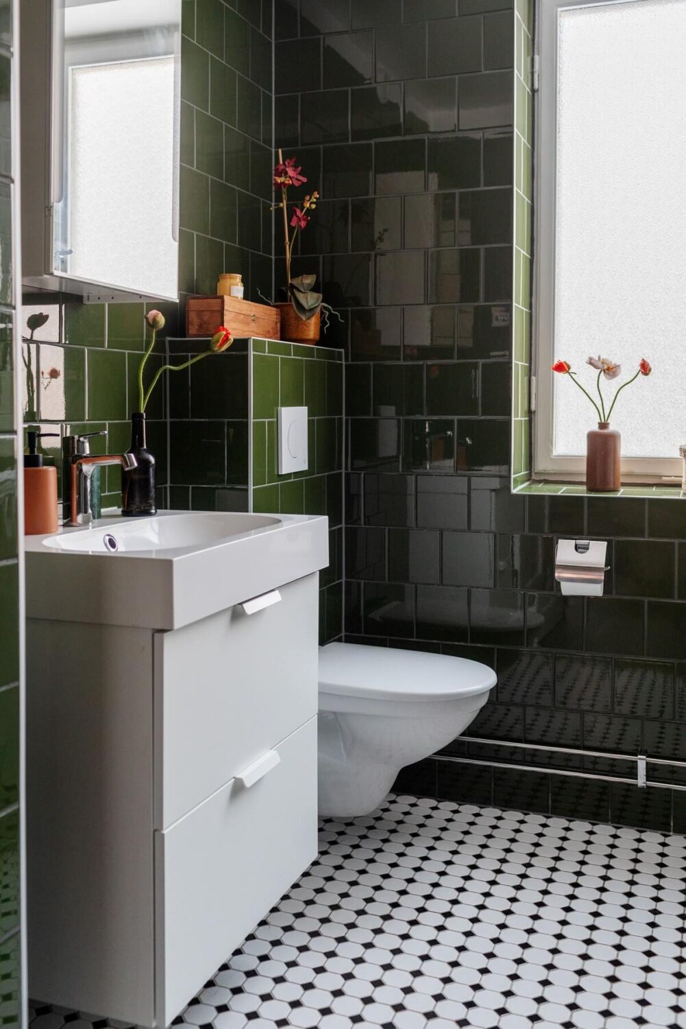 A Small Swedish Apartment with Warm Color Accents 22 glossy green tiles and black white floor tiles in small bathroom