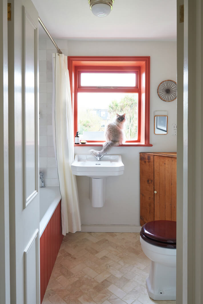 A Small Cottage-Style Apartment in London 13 bathroom with orange red details