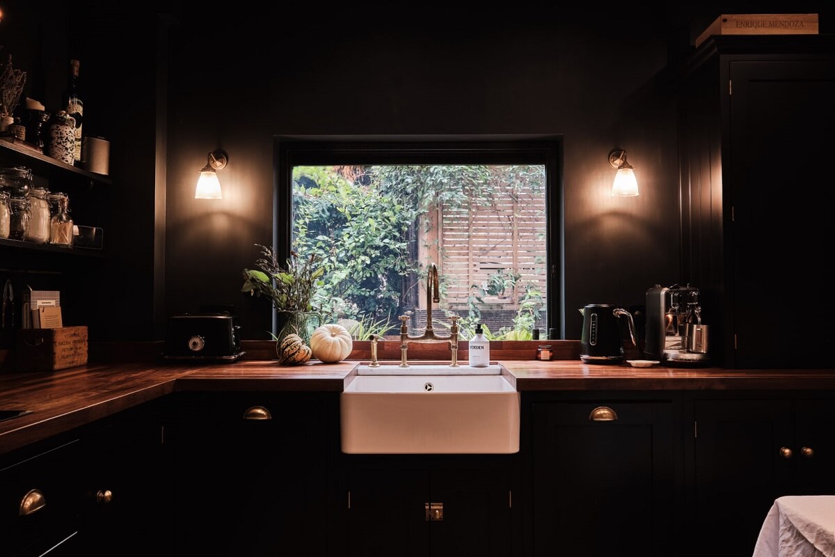 A London Warehouse Conversion with a Black deVOL Kitchen 13 butler sink under window in black devol kitchen