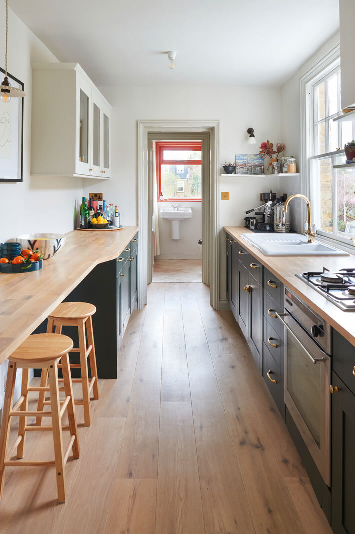 The Pros and Cons of a Wooden Kitchen Countertop 7 galley kitchen with green cabinets and bar seating