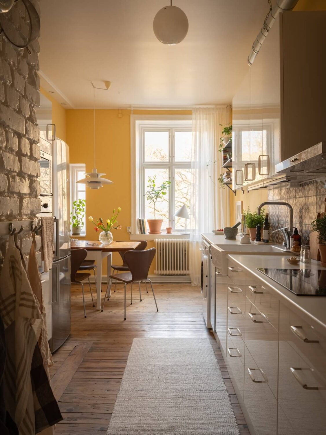 A Scandinavian Apartment with a Warm Living Room and Rounded Walls 12 kitchen with yellow painted walls