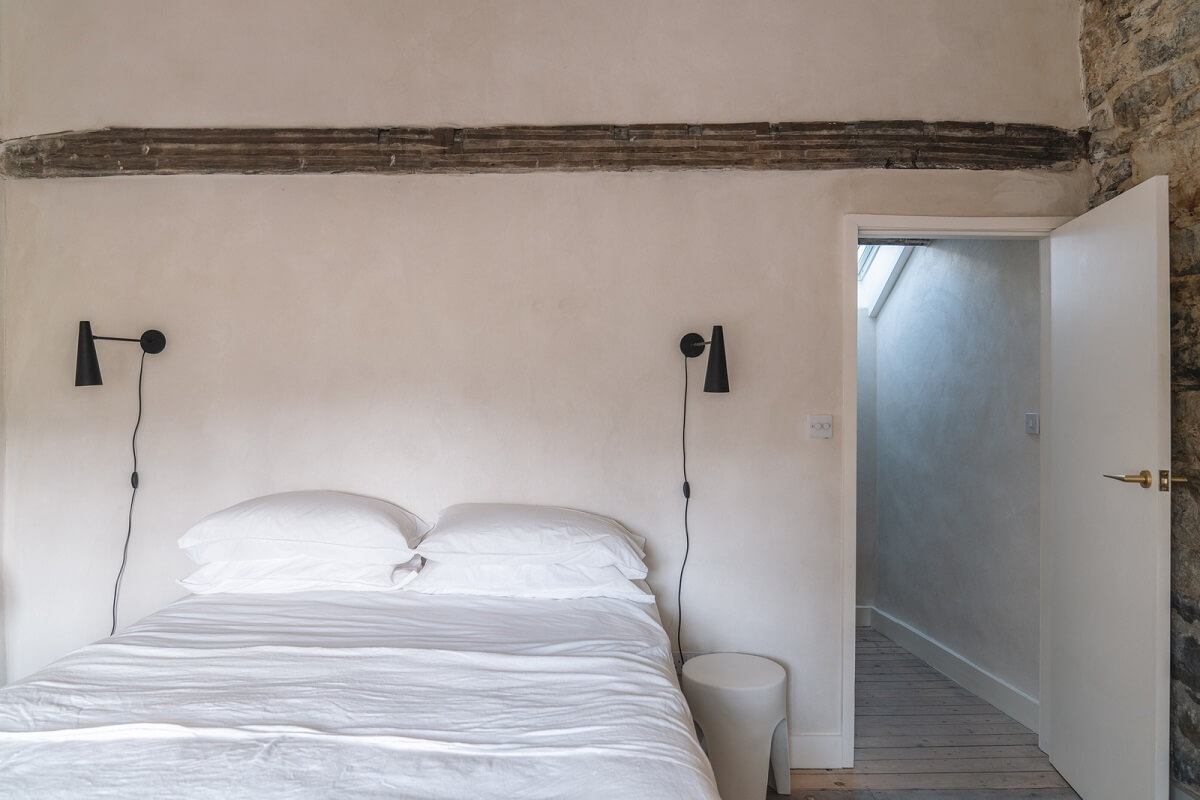 Contemporary Interiors in a Historic English House 13 light colored bedroom with stone wall