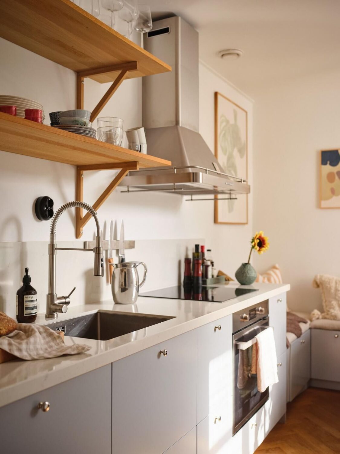 A Light Corner Apartment with a Pink Bedroom 11 light gray cabinets and wooden shelves