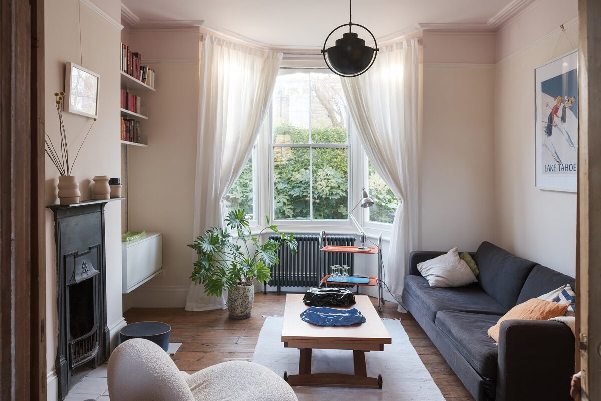 A London Home with Green Color Accents 1 living room with bay window and black fireplace