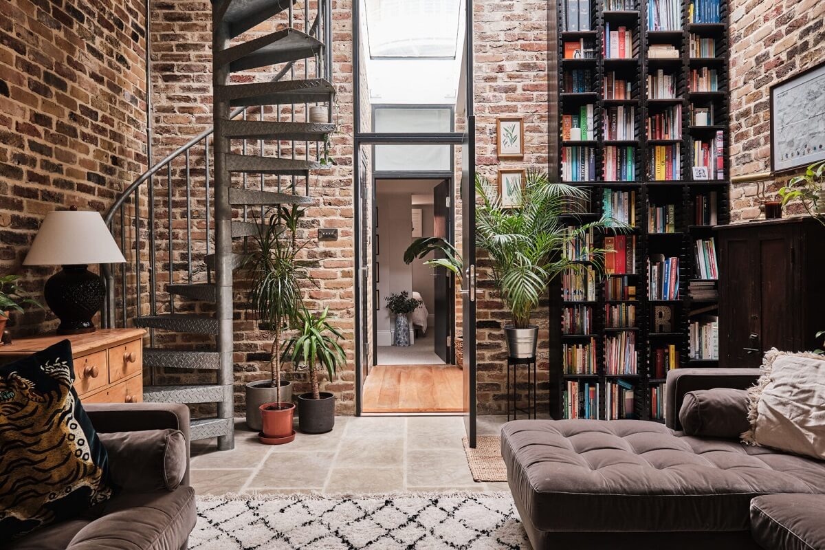 A London Warehouse Conversion with a Black deVOL Kitchen 1 living room with brick walls and floor to ceiling bookcases