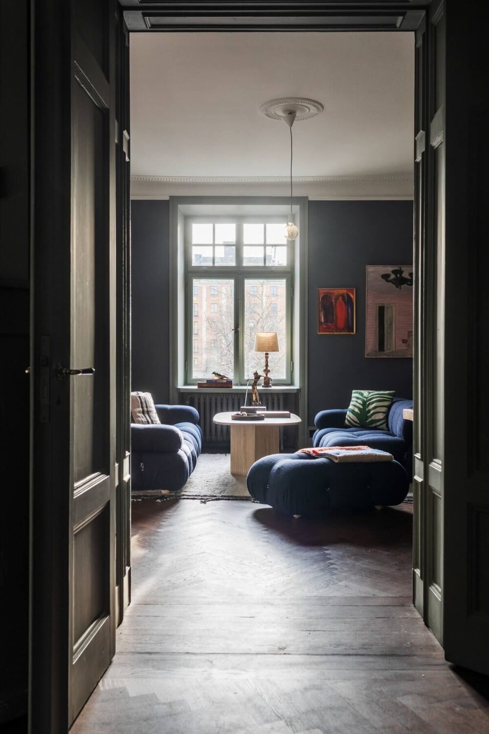 Moody Rooms in a Grand Stockholm Apartment 2 view into moody sitting room with blue walls
