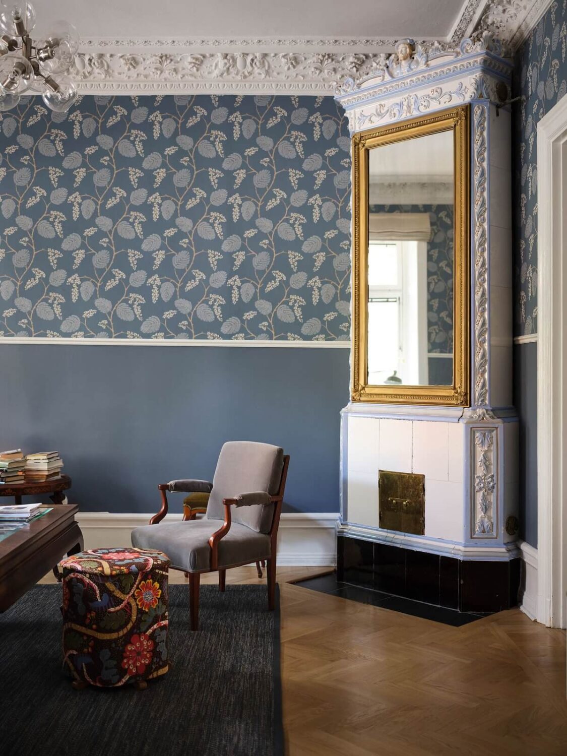 A Classic Stockholm Apartment with Floral Wallpaper 4 blue living room with floral wallpaper fireplace with gilded mirror nordroom