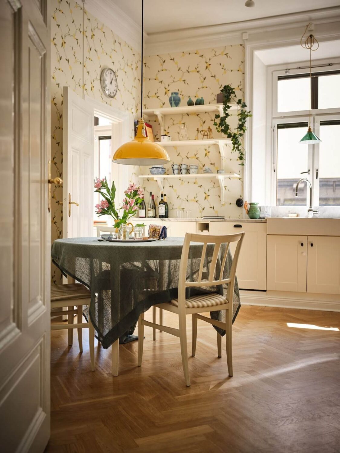 A Classic Stockholm Apartment with Floral Wallpaper 12 light cottage style kitchen with floral wallpaper round table and herringbone floor nordroom