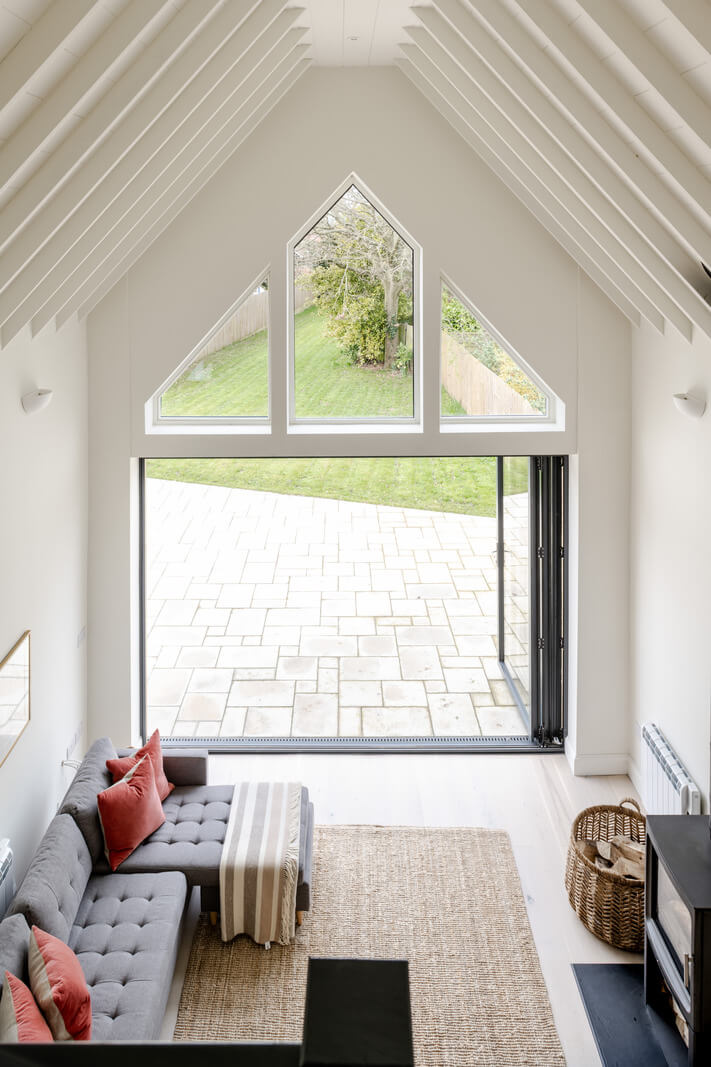 A Modern Barn House in the English Countryside 10 white living room pitched ceiling wooden beams nordroom