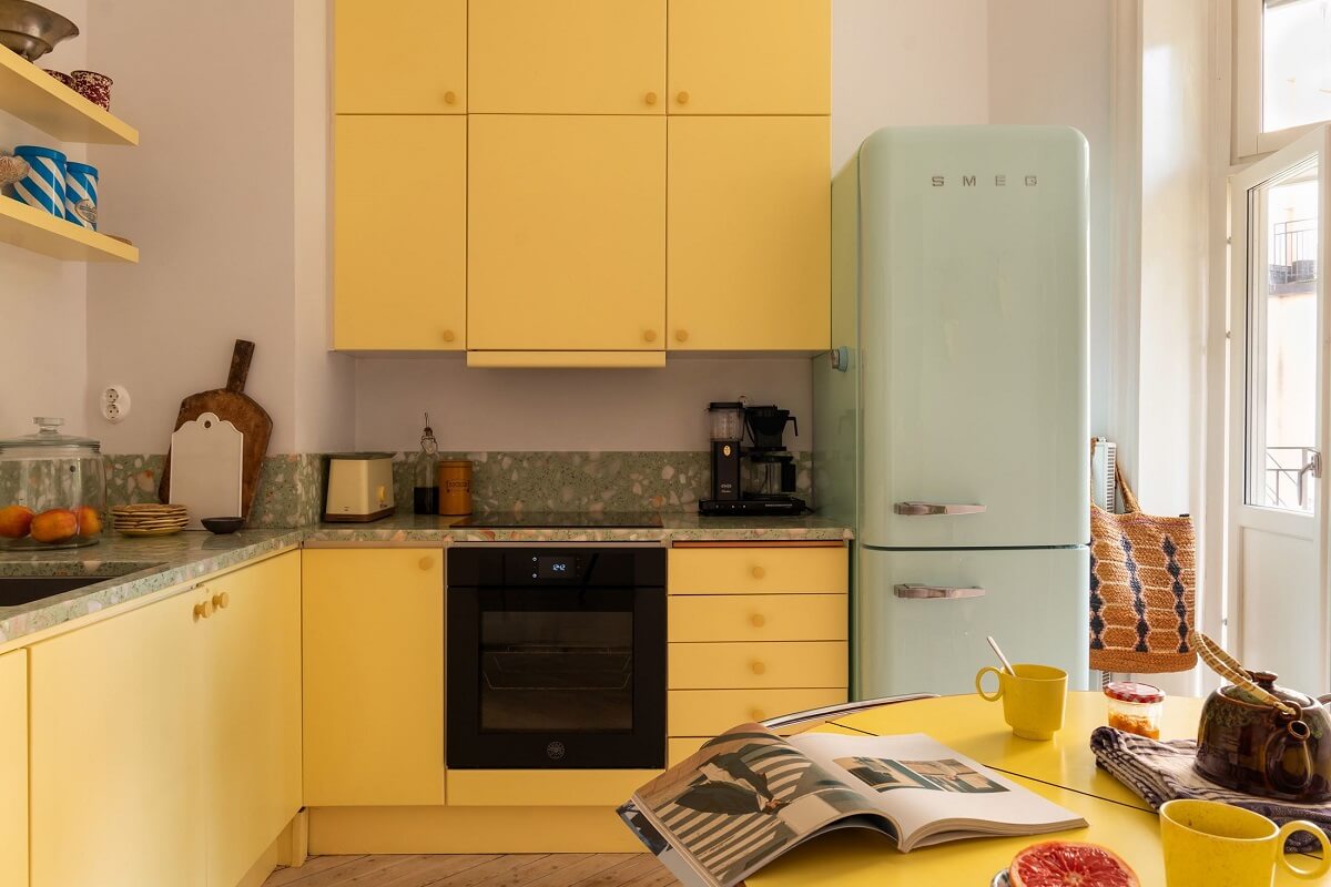 A Swedish Apartment with a Yellow Kitchen 2 yellow kitchen cabinets and mint green fridge