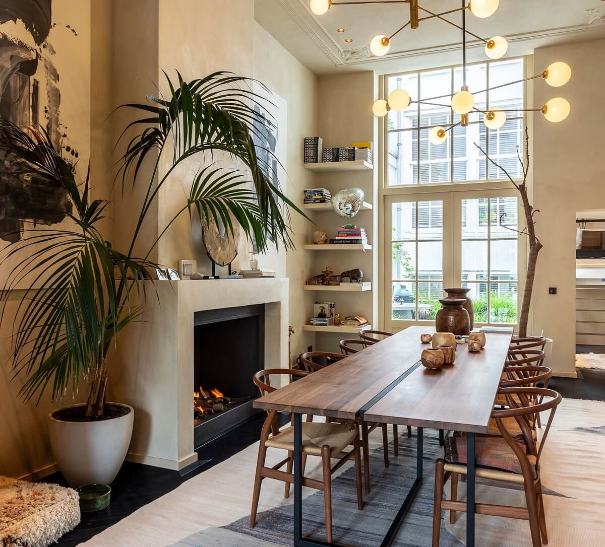 Best of 2024: Dining Rooms 7 dining room with floor to ceiling window fireplace and large wooden table with wishbone chairs