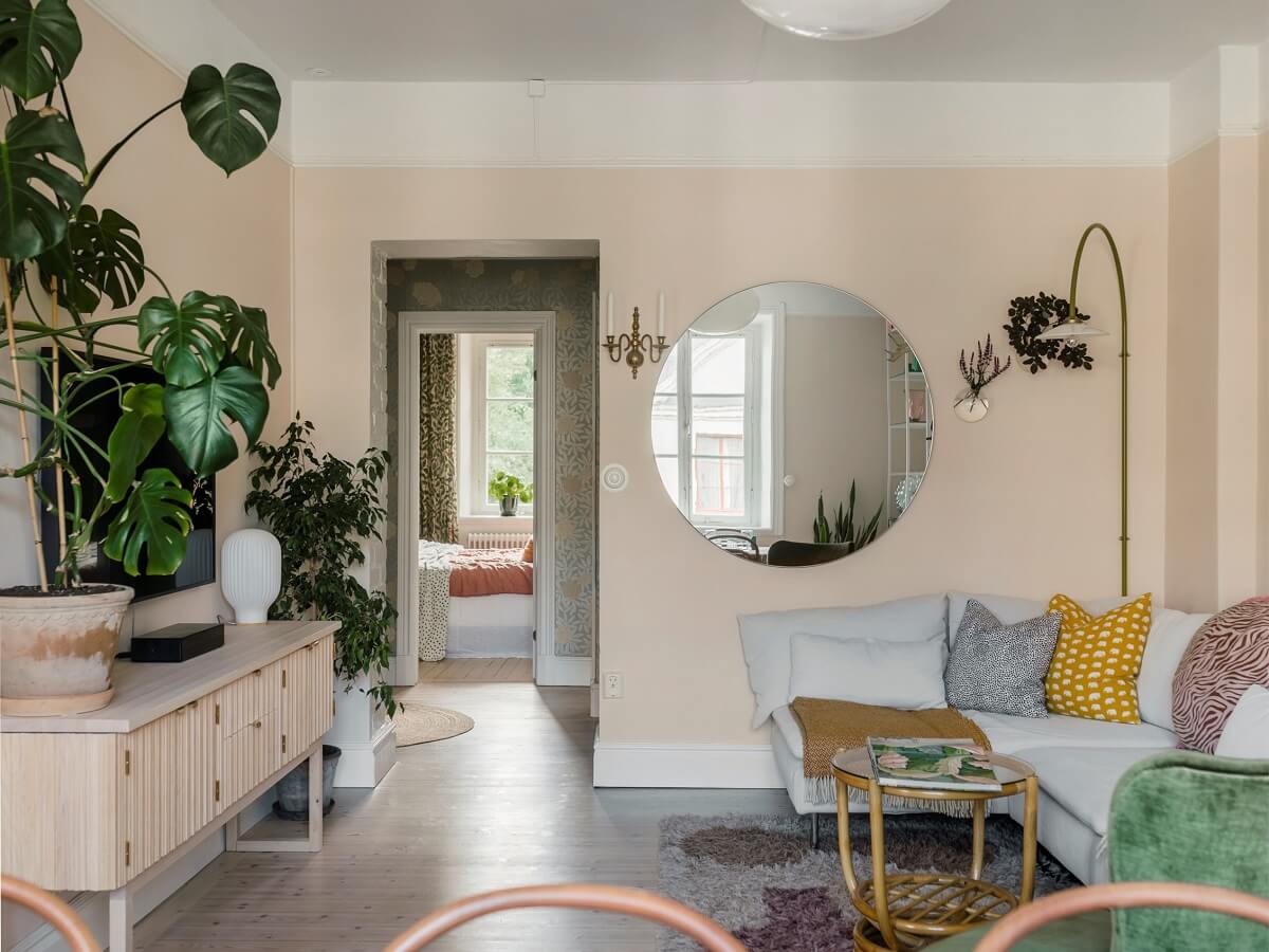 A Light Atmosphere and Wallpapers in a Swedish Apartment 1 living room pale pink walls round mirror nordroom