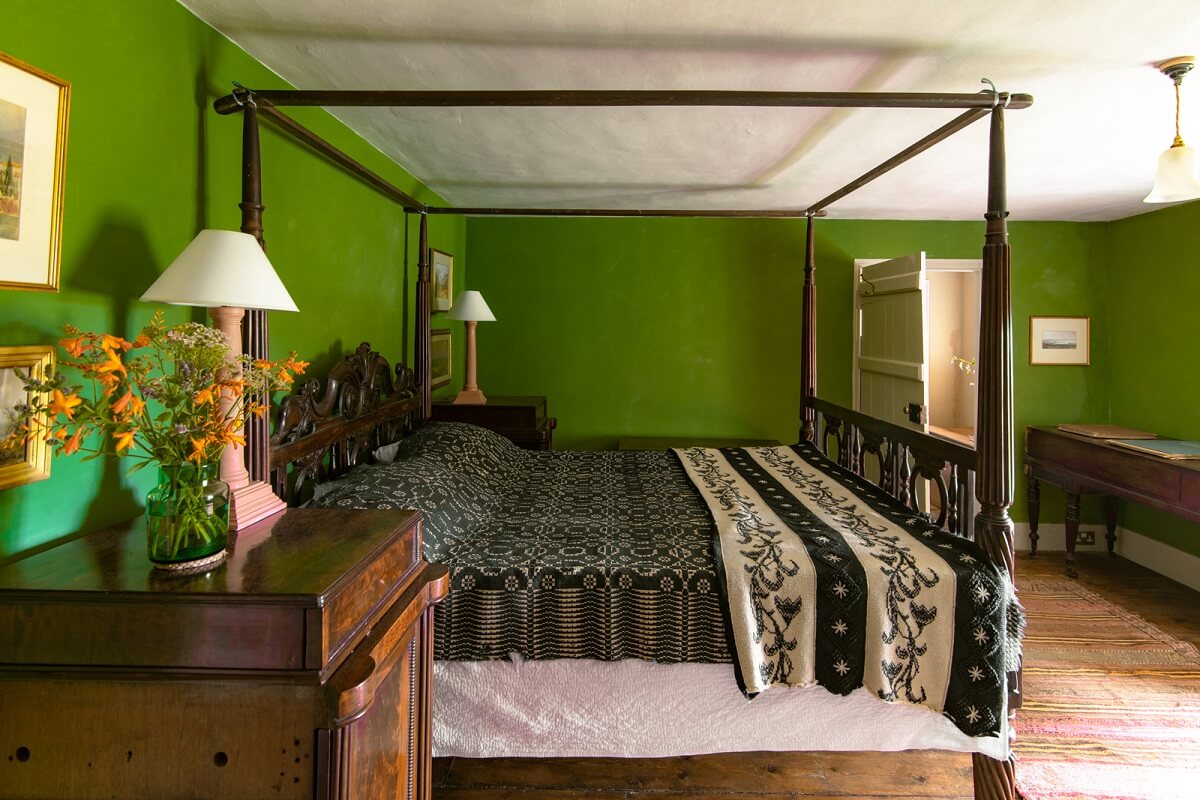A Yellow Farmhouse with Bold Color Pops in Wales 19 green walls bedroom canopy bed