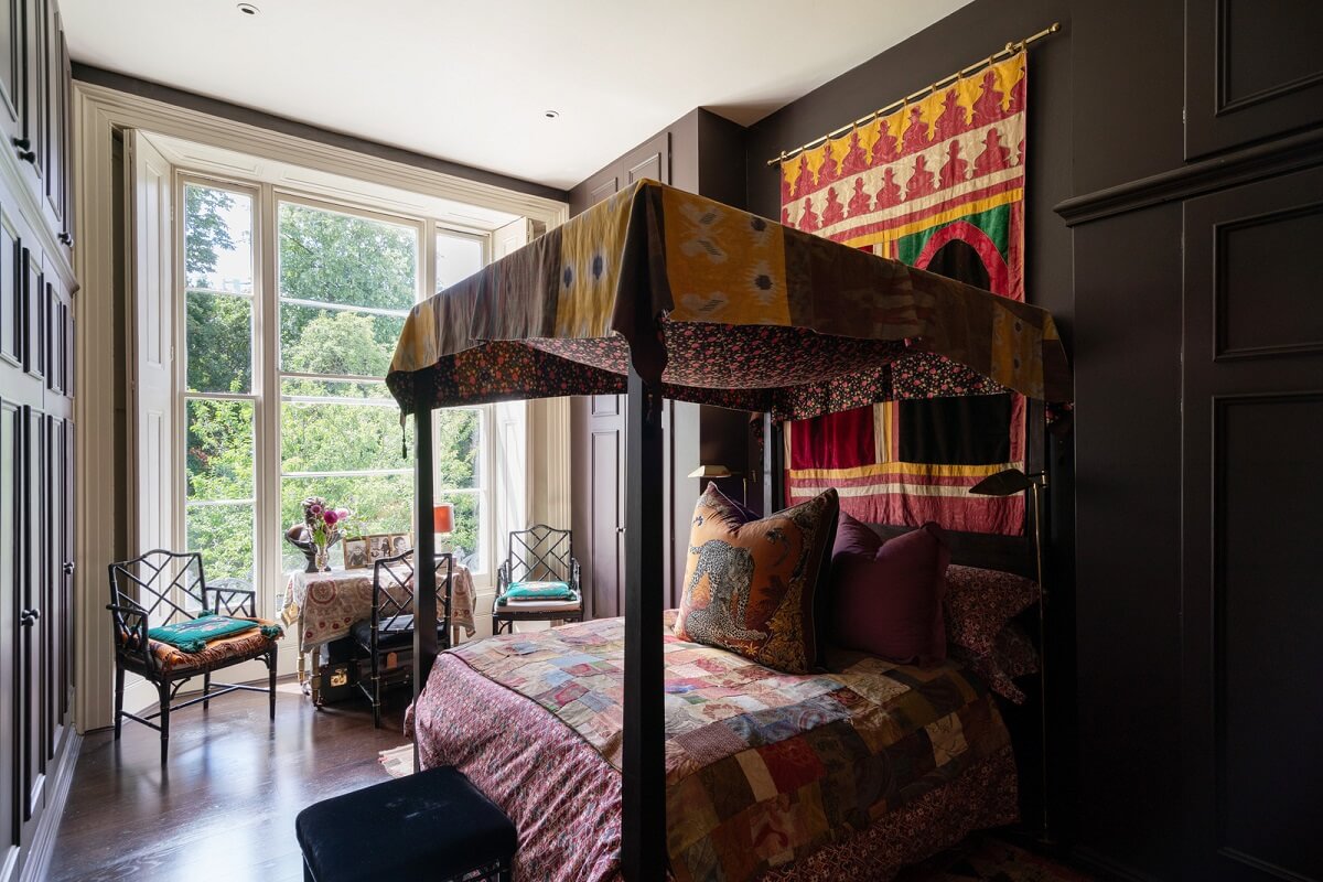 A Moody Color Palette and Eclectic Interiors in a London Apartment 11 moody bedroom with colorful canopy bed nordroom