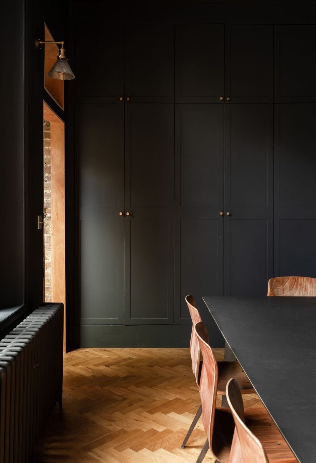 A Stunning Color Palette in an Extended Edwardian House in London 8 moody dark dining room with built in storage