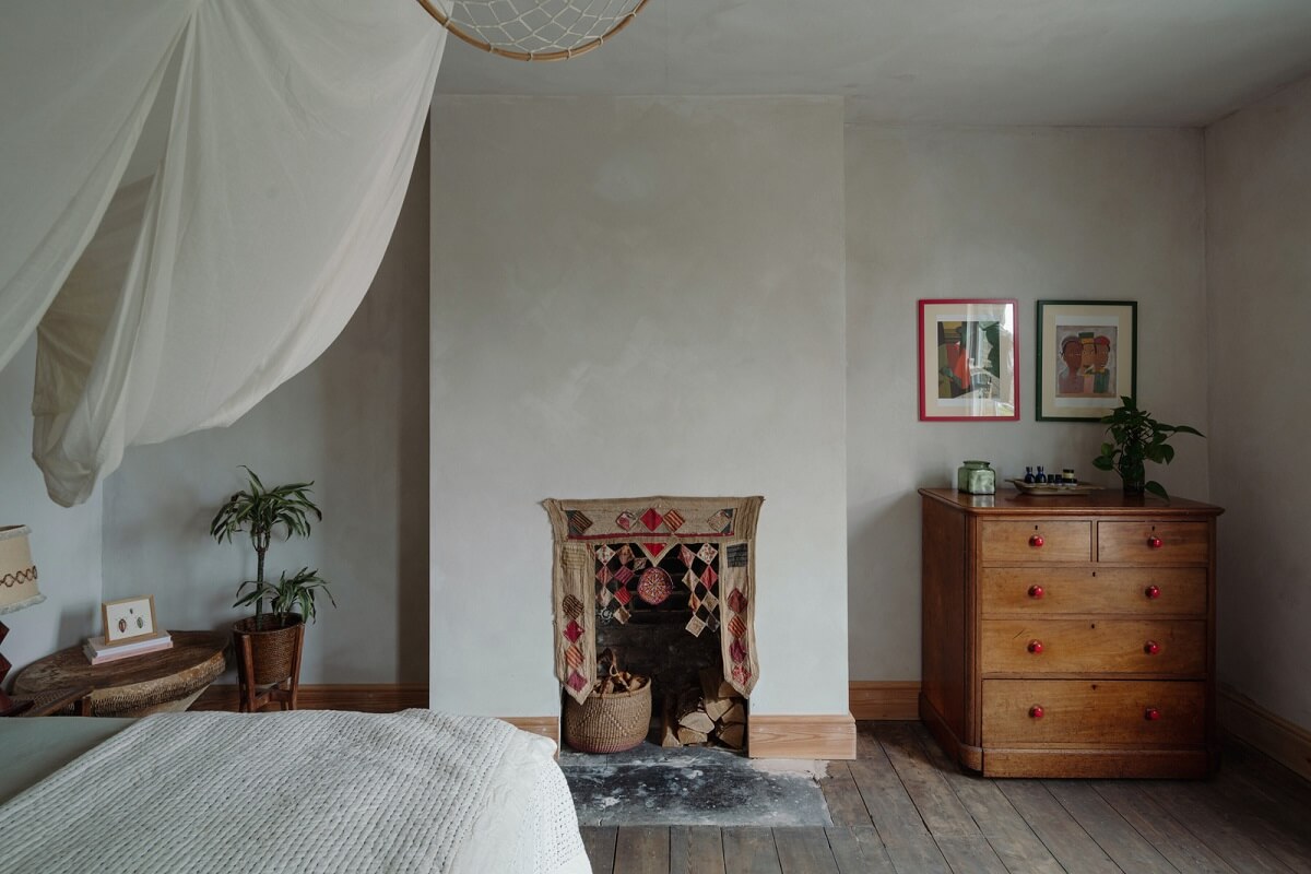 Pared Back Interiors in an English Home in Kent 20 bedroom with fireplace and canopy