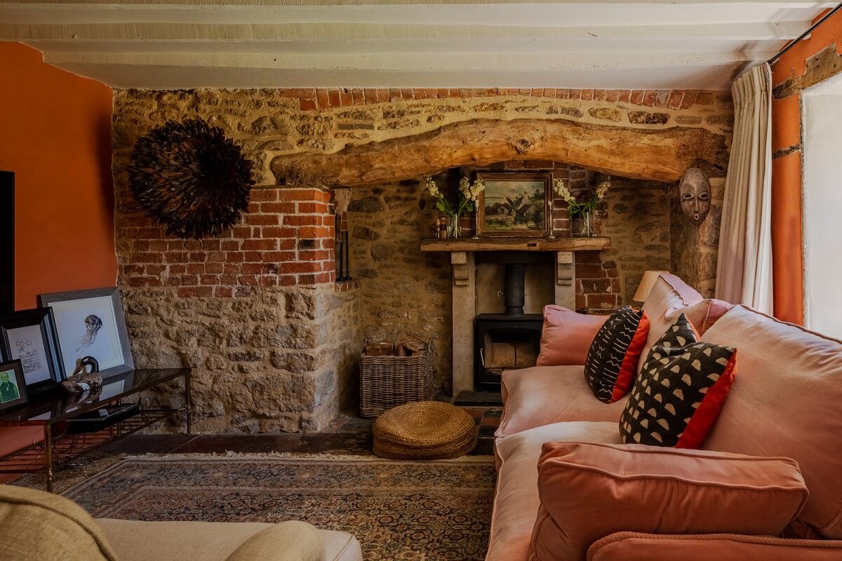 7 Simple Tricks To Make a Low Ceiling Look Taller 1 cottage living room with brick fireplace and orange walls nordroom