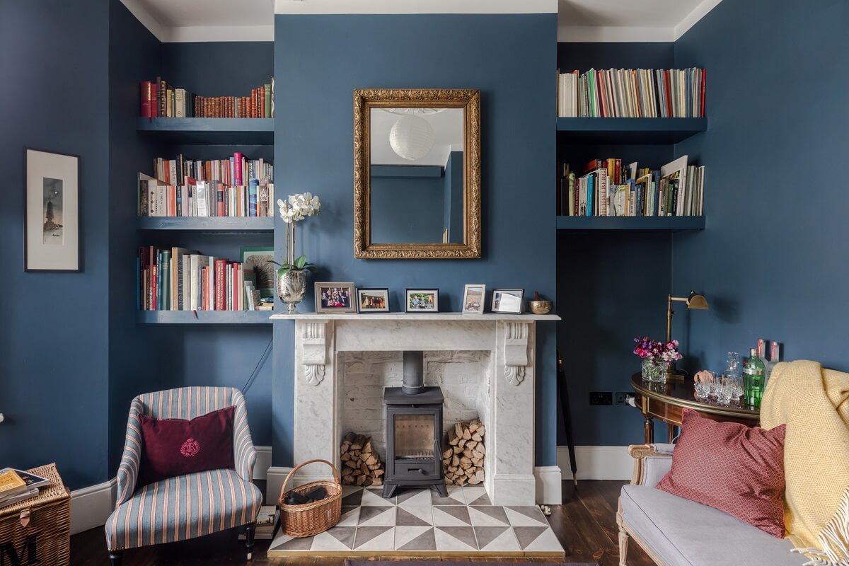 A London Apartment with a Deep Olive Green Kitchen 1 small blue living room with fireplace and bookshelves nordroom