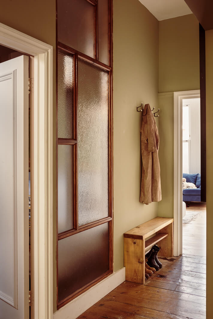 A Warm Ground Floor Apartment with Reclaimed Materials 17 hallway with window and shoe storage