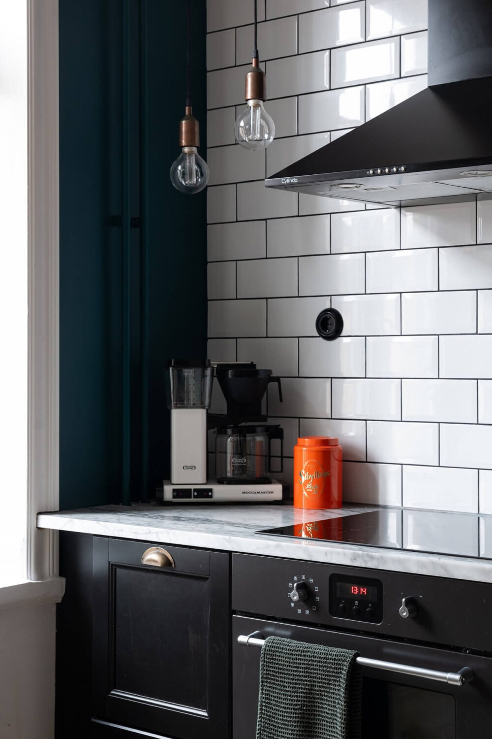 Colorful Art and Furniture in a Stylish Scandi Apartment 15 black kitchen with white tiles