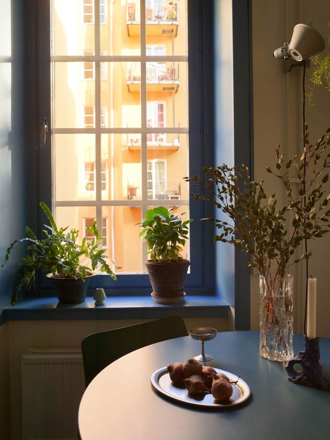 Golden Yellow Walls in a Colorful Swedish Studio Apartment 12 blue window frames and table kitchen nordroom