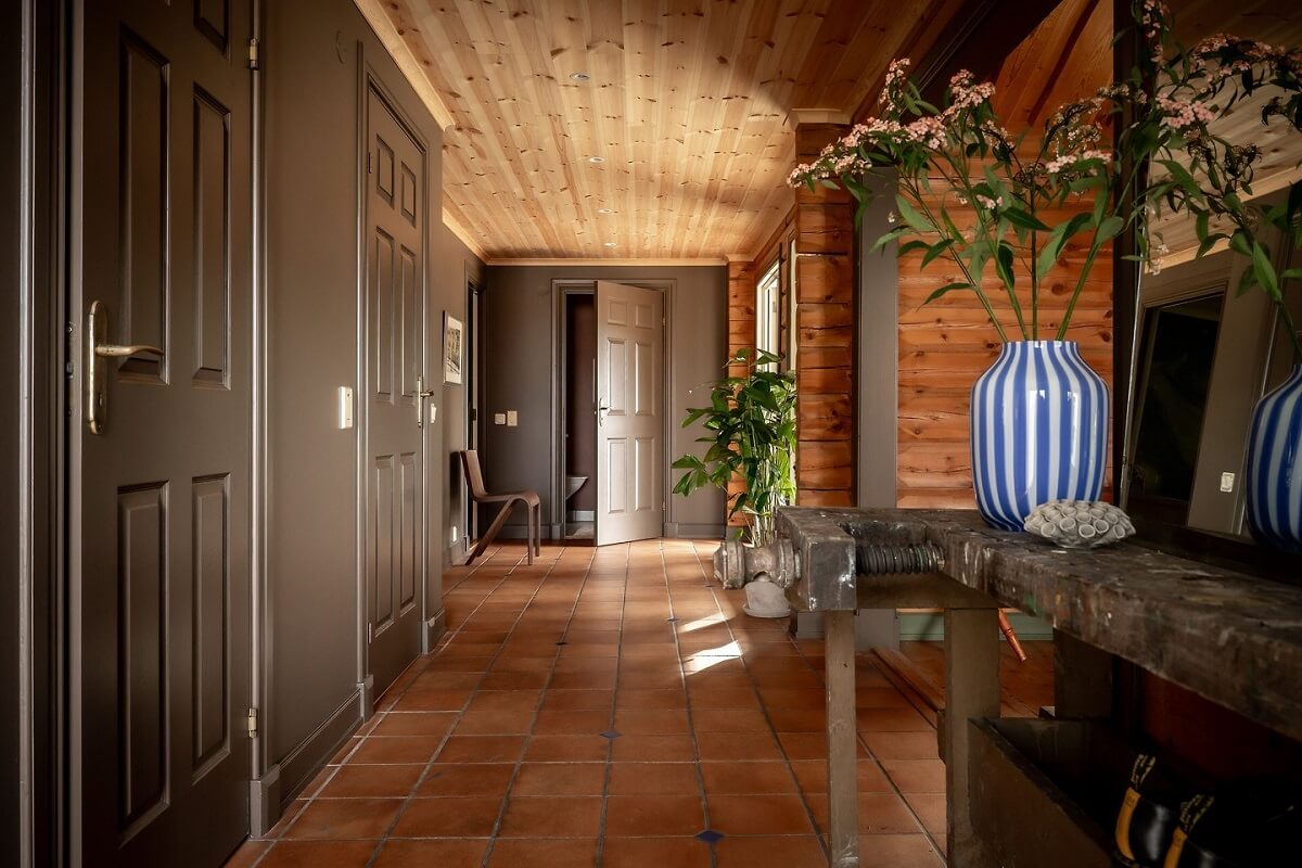 A Warm Scandinavian Log House with a Green Roof 14 log house hallway stone floor