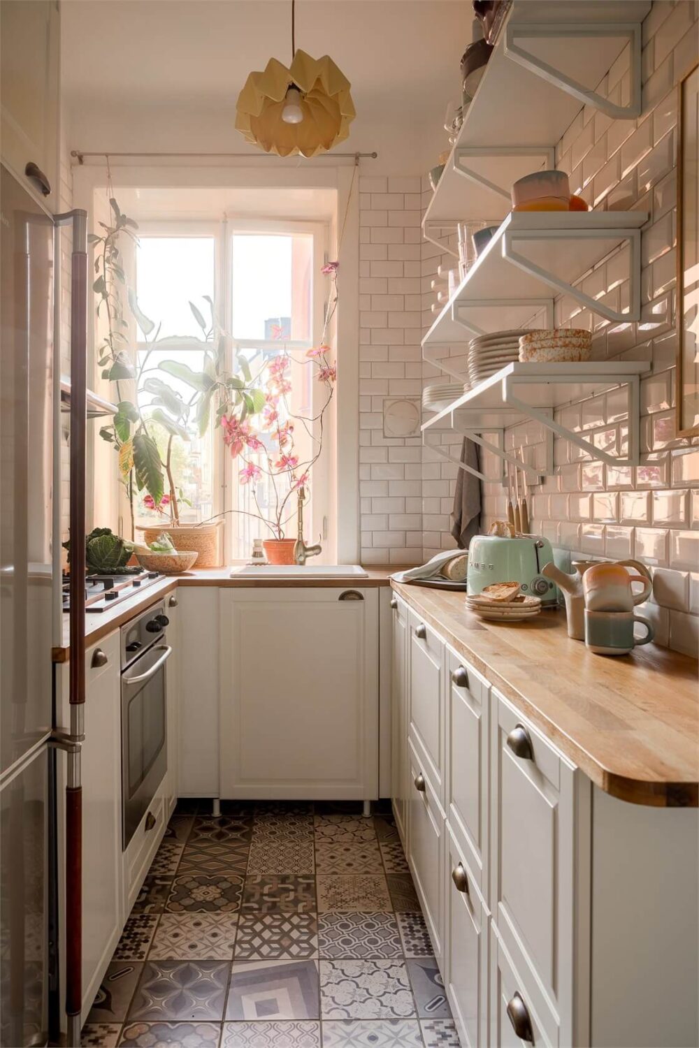 Nature-Inspired Colors in a Charming Stockholm Apartment 10 small kichen with white tiles cabinets and wooden worktop