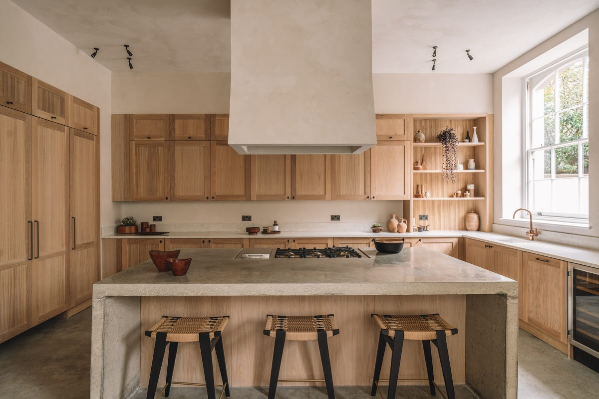 Contemporary Interiors with Limewash Walls in an Old School Building 1 wooden kitchen open and closed cabinets and island with bar seating nordroom