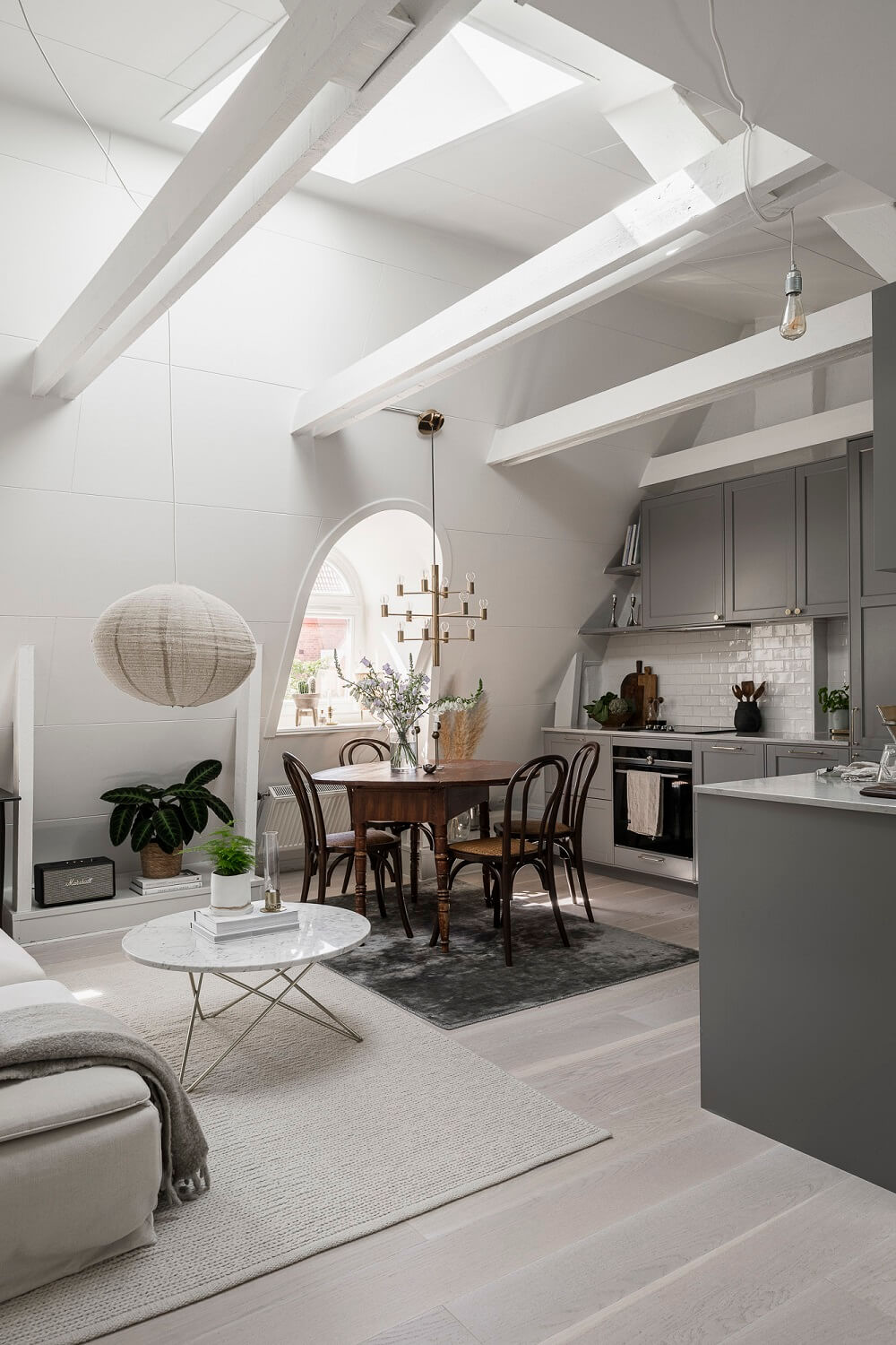 A Swedish Attic Apartment with a Lovely Balcony Overlooking the City 2 attic living room high pitched ceiling skylight gray kitchen nordroom